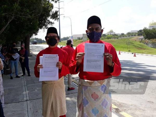 Syed Muhammad Imran (kanan) menunjukkan permohonan pengampunan diraja yang diserahkan di Istana Negara pada Jumaat.