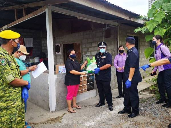 Yusuh menyampaikan beras kepada Rubiah dalam Op Bantu di Kampung Pulau Penampang, Kota Kinabalu.