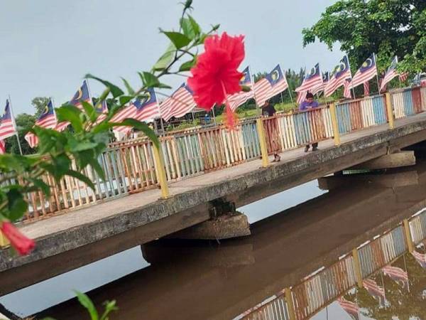 Jalur Gemilang dipasang di atas salah satu jambatan di tali air Kampung Gong Baru