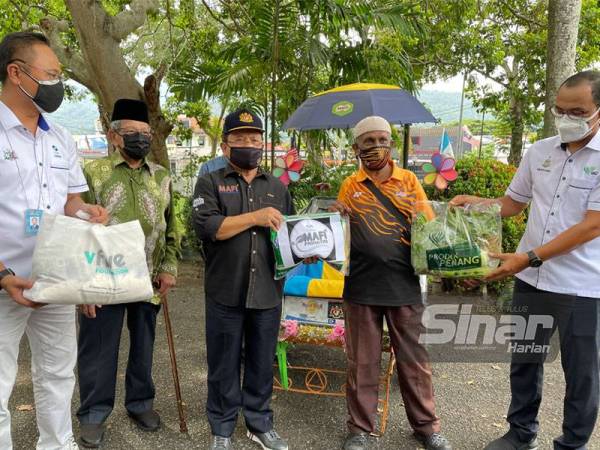 Ahmad (tiga dari kiri) menyerahkan bantuan kepada salah seorang penerima MAFI Prihatin di Wisma Anak Yatim Lelaki Pulau Pinang pada petang Sabtu.