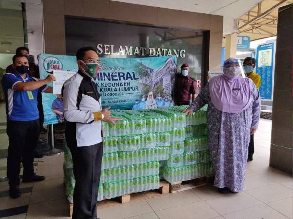 Khairil Nizam (kiri) ketika menyerahkan sumbangan air mineral kepada Pengarah HKL, Dr Rohana Johan pada Sabtu.