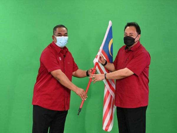 Muhammad Sanusi (kiri) menyerahkan Jalur Gemilang kepada Setiausaha Kerajaan Kedah, Datuk Ammar Shaikh Mahmood Naim sempena Majlis Pelancaran Bulan Kebangsaan dan Kibar Jalur Gemilang 2021, di Wisma Darul Aman pada Isnin.