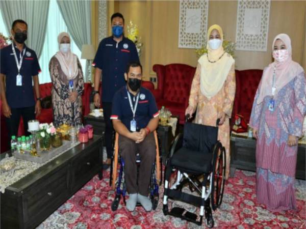 Juliah menyampaikan sumbangan kerusi roda kepada atlet paralimpik negeri Sabah, Muhamad Lizan di Rumah Yayasan Sabah, Kota Kinabalu.