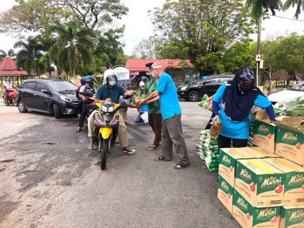 
Pengerusi Pertubuhan Kraf Malaysia (MCC), Nik Faiz Nik Amin (dua dari kanan) menyampaikan bakul makanan kepada 100 penerima di Taman Kemahkotaan @ Pata Ndo, Tumpat pada Rabu.