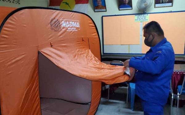 Anggota Angkatan Pertahanan Awam (APM) memastikan kemudahan PPS Dewan UMNO Gurun mencukupi untuk menempatkan mangsa banjir.- Foto ihsan APM Kedah