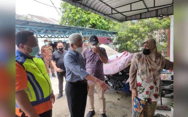 Azrul (kiri) mengiringi Ahmad Zakiyuddin (tengah) melawat mangsa banjir di Teluk Kumbar pada Khamis.