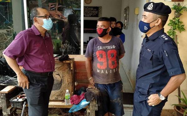 Abdullah Hashim (kiri) melawat kawasan terjejas akibat fenomena kepala air bersama Ketua Polis Daerah Kuala Muda Asisten Komisioner Adzli Abu Shah.