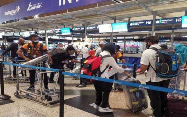 Kakitangan Malaysia Airlines membantu atlet para melancarkan proses pemeriksaan di kaunter berlepas KLIA sebelum berlepas ke Sukan Paralimpik Tokyo 2020. - Foto Bernama