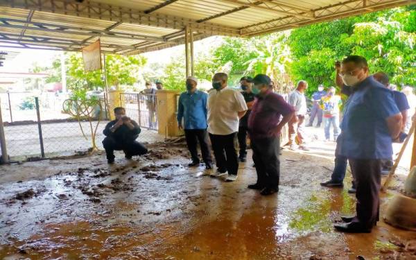 Muhammad Sanusi (tiga dari kiri) melawat rumah penduduk yang dimasuki lumpur akibat fenomena kepala air di Gunung Jerai pada Jumaat.