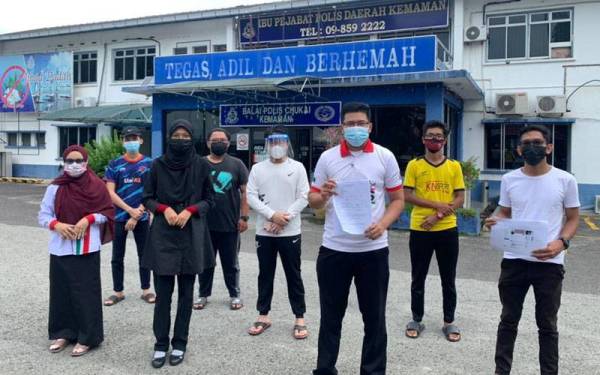 Ahmad Amri Kursani Hassan (dua kanan, depan) bersama sebahagian ahli jawatankuasa GPMS cawangan Kemaman menunjukkan salinan laporan polis selepas selesai membuat laporan.