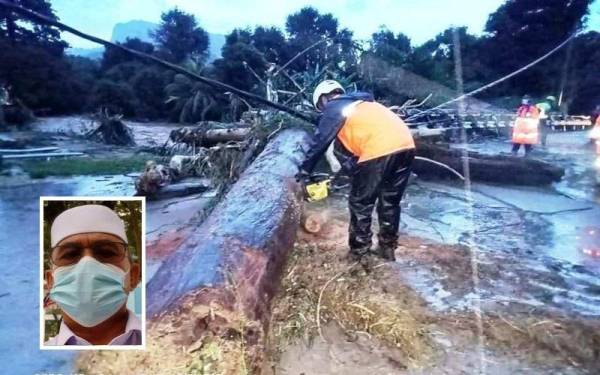 Pasukan keselamatan memotong pokok tumbang yang dihanyutkan oleh banjir besar bagi membuka laluan selepas air surut. Gambar kecil: Zulkifli Yahaya