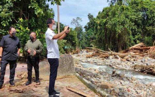 Tunku Sarafudin Badlishah (kanan) meninjau keadaan Pusat Rekreasi Titi Hayun, dekat sini pada Sabtu. Turut kelihatan, Ammar (kiri).