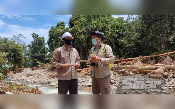 Abdullah (kiri) dan Ferdaus meninjau kesan kepala air di Pusat Rekreasi Titi Hayun, Yan pada Sabtu.