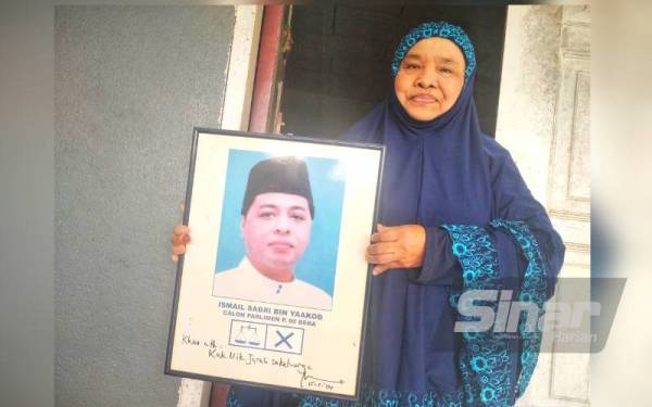 Jaharah menunjukkan poster Ismail Sabri ketika bertanding dalam Pilihan Raya Umum pada 2004 yang masih disimpan rapi hingga kini.