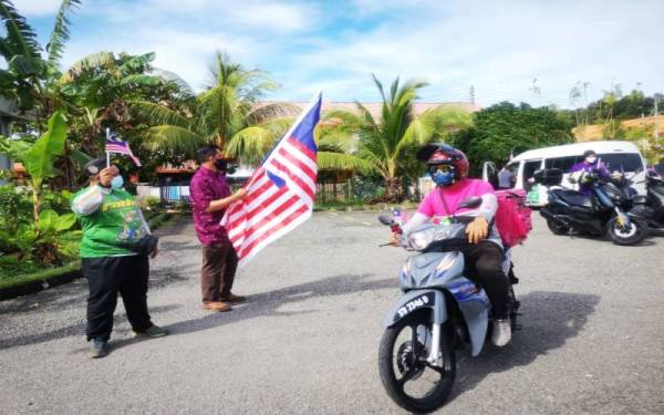 Aliakbar melepaskan konvoi mengedar Jalur Gemilang di Surau Al-Amin Putera Perdana, Telipok, Kota Kinabalu.