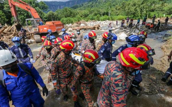 Anggota SAR membawa keluar mayat mangsa kelima yang ditemui di bawah timbunan kayu di kawasan Titi Hayun, Yan pada Ahad.