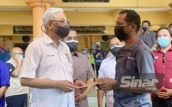 Ismail Sabri (kiri) menyampaikan sumbangan kepada waris mangsa yang terkorban dalam tragedi kepala air di Gunung Jerai pada Isnin.