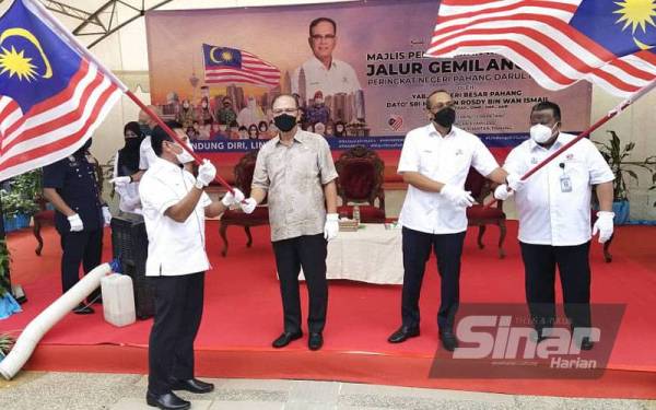 Wan Rosdy (dua dari kiri) menyerahkan Jalur Gemilang kepada Hamdan mewakili MBK pada Pelancaran Kempen Kibar Jalur Gemilang 2021 Peringkat Negeri Pahang di pekarangan Kompleks Majlis Bandaraya Kuantan pada Isnin.