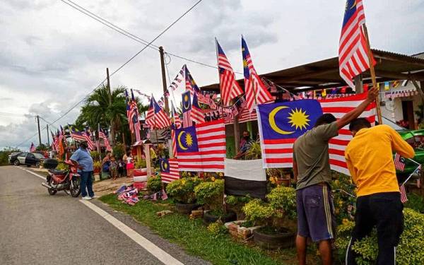 Penduduk bekerjasama memasang Jalur Gemilang di penempatan tersebut.