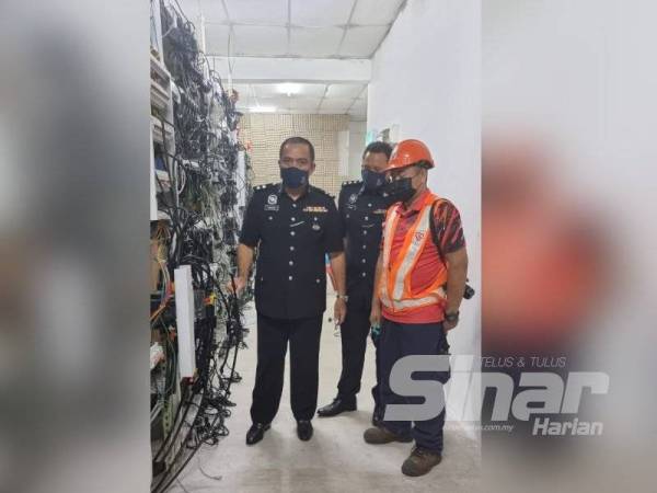 Sazalee (kiri) memeriksa premis yang dijadikan lokasi melombong mata wang digital bitcoin di Kulim, Kedah.