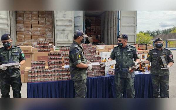 Zainal Abidin (dua, kanan) menunjukkan antara rampasan menerusi Op Kontraban yang dijalankan sepasukan polis dari Batalion 4 PGA, di sekitar Lembah Klang pada Selasa.