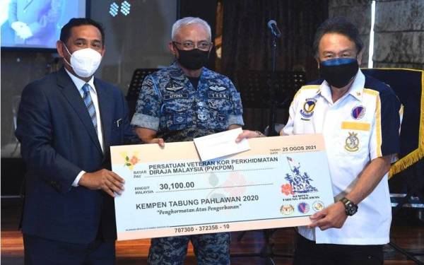 Affendi (tengah) bersama Muez (kiri) menyerahkan replika cek dana kepada wakil Persatuan Veteran Kor Perkhidmatan Diraja Malaysia, Mejar Rozni Hashim di Wisma Perwira Angkatan Tentera Malaysia (ATM) pada Rabu. - Foto Bernama