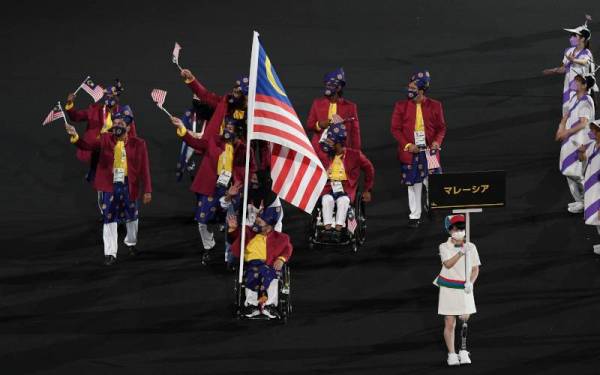 Atlet powerlifting paralimpik negara, Bonnie Bunyau Gustin bersama atlet olahraga paralimpik negara Siti Nooriasah Mohamad Ariffin membawa Jalur Gemilang pada upacara pembukaan Sukan Paralimpik Tokyo 2020 di Stadium Olimpik.