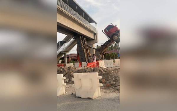 Lori tanah yang tersangkut pada jejantas di Kilometer 44 Jalan Klang-Teluk Intan, berhampiran Taman Penggawa, Sungai Lias pada Khamis.