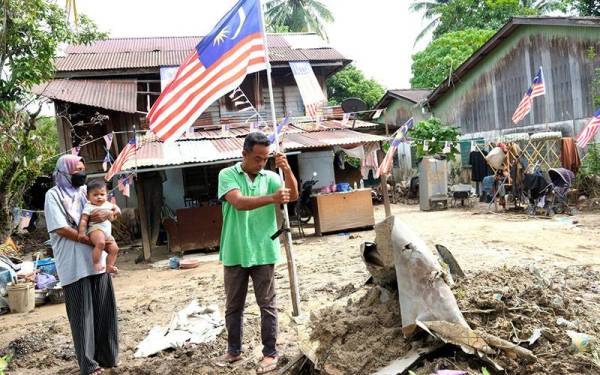 Rosli bersemangat mengibarkan Jalur Gemilang di rumahnya di Jalan Masjid, Yan di sini. - Foto Bernama