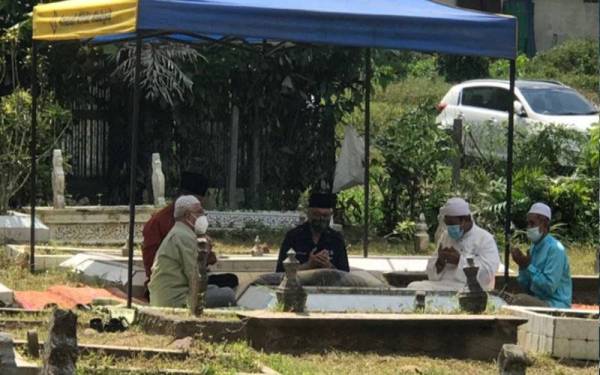 Ismail Sabri (tengah) ketika menziarahi pusara ibu bapanya di Tanah Perkuburan Islam Lubuk Kawah, Temerloh pada Sabtu.