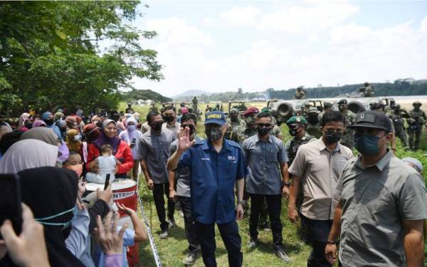 Ismail Sabri (tengah) sempat beramah mesra dengan penduduk ketika hadir menyaksikan Eksesais Para Predator Siri 1/2021 di Kampung Bukit Bor, pada Sabtu. - Foto Bernama 