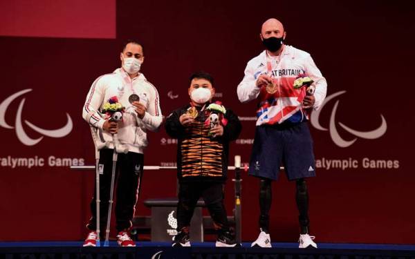 Atlet powerlifting paralimpik negara, Bonnie Bunyau Gustin (tengah) bergambar dengan atlet dari Mesir dan Great Britain, Attia Mahmoud (kiri) dan Yule Micky setelah berjaya meraih pingat emas pertama negara bagi kategori 72kg pada Kejohanan Sukan Paralimpik Tokyo 2020 di Tokyo International Forum pada Sabtu. - Foto Bernama