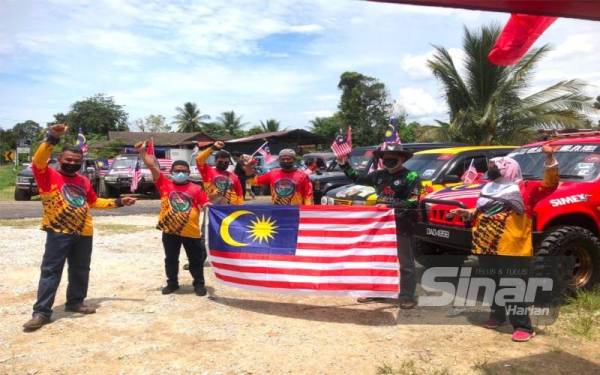 Saiful Azli (dua dari kiri) bersama ahli kelab mengibar Jalur Gemilang di Kampung Teratak Pulai, Jelawat, Bachok pada Ahad.