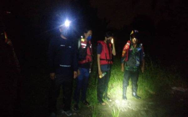 Pihak bomba dengan bantuan orang asli mencari mangsa terperangkap dalam banjir di kebun kelapa sawit di Jalan Kampung Sungai Melut, Dengkil pada Ahad.