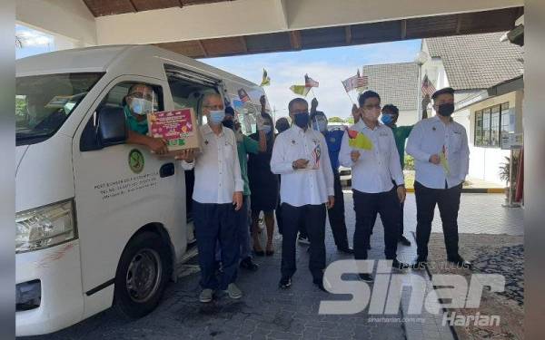 Haziz (kiri) ketika menyampaikan sumbangan bakul makanan secara pandu lalu kepada pekerja hotel yang terjejas pada Isnin.