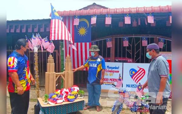 Muhamad Arif (kiri) bersama ahli jawatankuasa Persatuan Taman Sri Purnama meninjau kediaman penduduk yang dihiasi cantik dengan Jalur Gemilang.