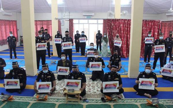 Antara anggota dan pegawai polis Ibu Pejabat Polis Daerah Jelebu yang menyertai Malaysia#QuranHour di surau IPD Jelebu pada Isnin.