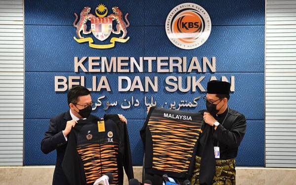 Ahmad Faizal (kanan) dan Ti Lian Ker (kiri) menerima jaket rimau sebagai simbolik memulakan tugas secara rasmi di Kementerian Belia dan Sukan sejurus selepas mengangkat sumpah sebagai menteri di Istana Negara hari ini. - Foto Bernama