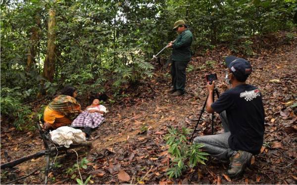 Nur Zamri (kanan) merakam babak penduduk kampung diserang oleh pengganas komunis ketika menghasilkan video pendek bertajuk Ini Tanah Kita ketika ditemui di Bukit Bendera, Pantai Teluk Mak Nik. - Foto Bernama 