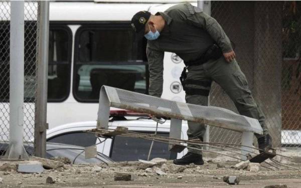 Seorang pegawai polis memeriksa kerosakan di pondok polis setelah bom meletup di Cucuta, Colombia pada Isnin. - Foto AP 