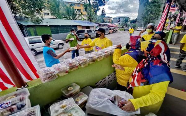 Ahli jawatankuasa masjid mengagihkan nasi ayam percuma kepada penduduk