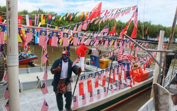 Mohd Azam bergambar bersama botnya yang dihiasi bendera ketika perarakan pada Selasa.