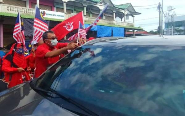 Mohamed Farid memasang Jalur Gemilang pada kenderaan orang ramai sempena sambutan Hari Kebangsaan ke-64 di sekitar Berek 12, Kota Bharu pada Selasa.