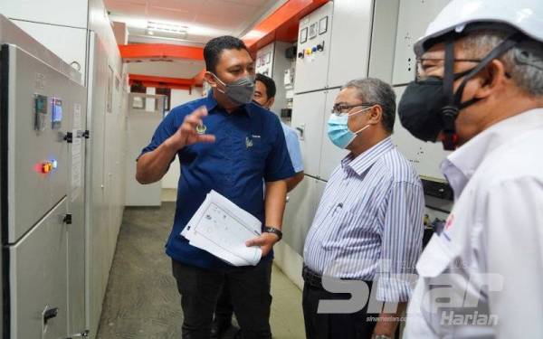 Rumaizi mendengar penerangan di tapak Projek Solar PV di Bangunan UTC Ipoh di sini.