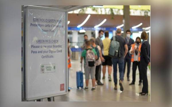 Papan tanda memberitahu para penumpang harus menunjukkan segala dokumen diperlukan termasuk sijil vaksinasi sebelum dibenarkan melakukan perjalanan. - Foto AP Newsroom