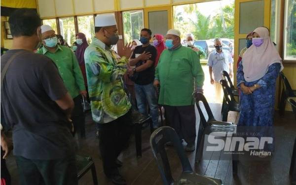 Idris beramah mesra dengan mangsa banjir yang menerima sumbangan ketika hadir menyampaikan Bantuan Musa'adah Banjir di Dewan Orang Ramai Matang Gelugor, Matang pada Ahad.