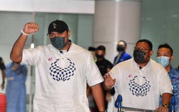 Muhammad Ziyad (kiri) bersama jurulatihnya ketika tiba di Lapangan Terbang Antarabangsa Kuala Lumpur (KLIA) pada Jumaat.