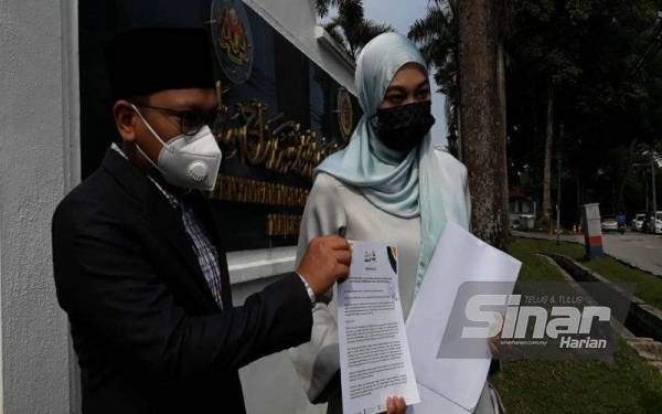 Pengarah Reset Malaysia, Dr Abu Hafiz Salleh Huddin (kiri) dan Ketua Sekretariat Reset Malaysia, Dr Nurul Ashikin Mabahwi menunjukkan memorandum kepada media di pekarangan pintu masuk Pejabat Penyimpan Mohor Besar Raja-raja, Kuala Lumpur pada Isnin.