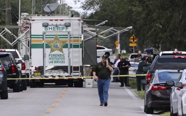 Pihak berkuasa mengawal jalan raya menuju ke lokasi kejadian tembakan di Mukim Polk, Florida pada Ahad. - Foto AP