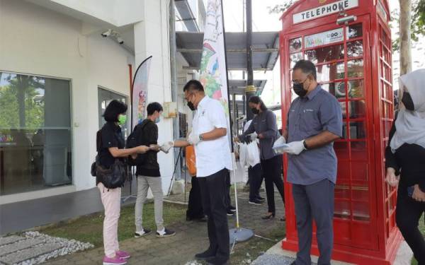 Mohd Sharkar (tiga kiri) menyampaikan Bantuan Prihatin Pahang (BPP) kepada wakil persatuan pemandu pelancong Kuantan dan Cherating di pekarangan pejabat Tourism Pahang, pada Selasa.